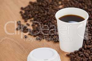 Coffee beans and black coffee in disposable cup