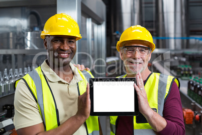 Portrait of factory workers holding digital tablet in the plant