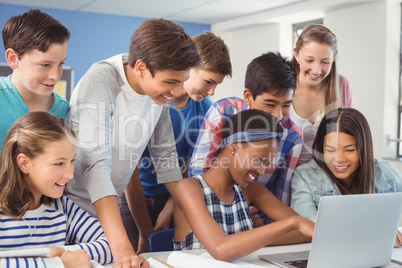 Group of students using laptop in classroom