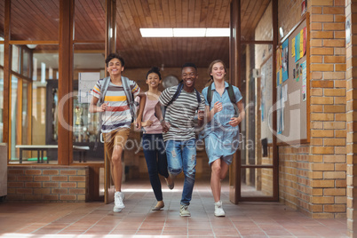 Excited classmates running in corridor