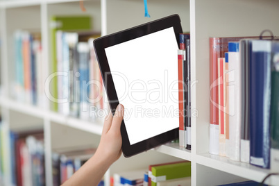 Hand of student keeping digital tablet in bookshelf in library