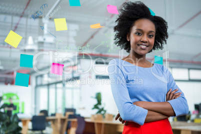 Female graphic designer standing with hands crossed in creative office