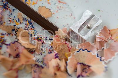 Colored shavings with brown color pencil and sharpener in saucer