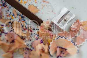 Colored shavings with brown color pencil and sharpener in saucer