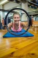 Portrait of fit woman exercising with pilates ring in fitness studio