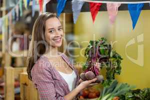 Smiling woman choosing vegetables in grocery store