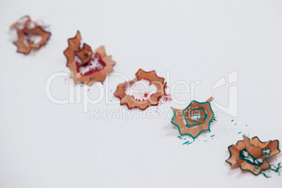 Red, blue and green colored pencil shavings on white background