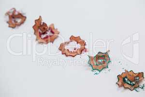 Red, blue and green colored pencil shavings on white background