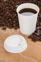 Coffee beans and black coffee in disposable cup