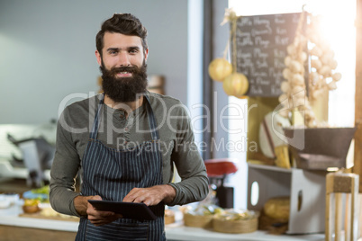 Portrait of salesman using digital tablet at counter