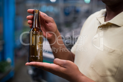 Factory worker holding empty bottle
