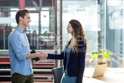 Business executives shaking hand in office