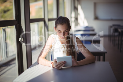 Schoolgirl using digital tablet in classroom