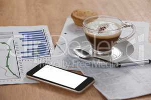 Coffee cup with document and mobile phone