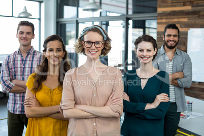 Business executives standing with arms crossed in office