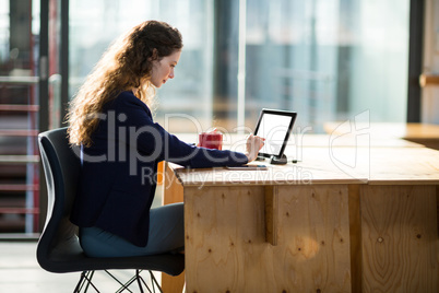 Female business executive using digital tablet at desk