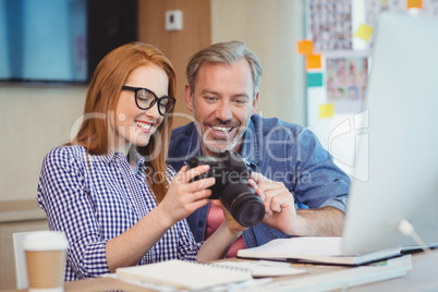 Two graphic designers looking at pictures in digital camera