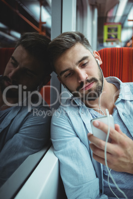Executive looking at mobile phone while listening music