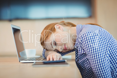 Female graphic designer sleeping on desk