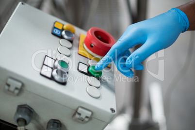 Factory engineer pressing button in bottle factory