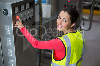 Female factory worker operating machine