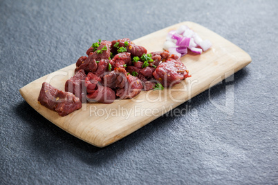 Diced beef and onions on wooden board
