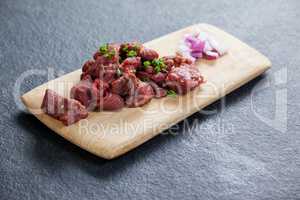 Diced beef and onions on wooden board