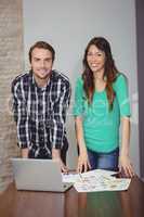 Portrait of male and female graphic designers standing in conference room
