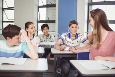 School students passing a chit in a secretive way inside the classroom