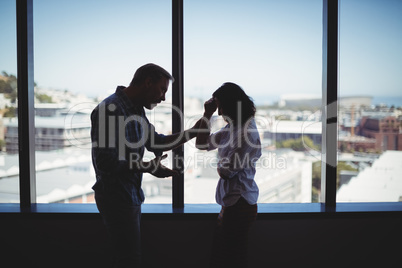 Business couple arguing near the window