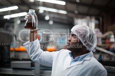 Factory engineers checking a sample of drink