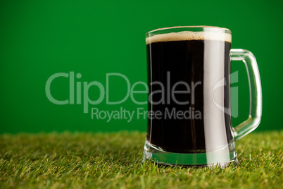 Mug of green beer on grass for St Patricks Day