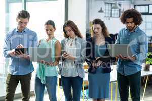 Group of business executives using digital tablet, mobile phone and laptop