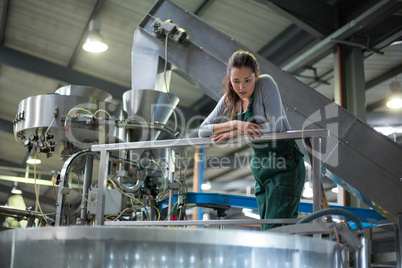 Female factory worker inspecting a storage tank