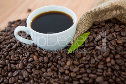 Coffee cup with coffee beans and coffee leaf