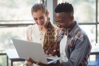 Schoolkids using laptop in classroom