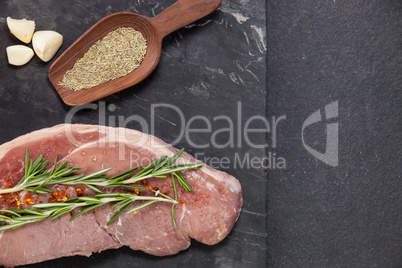 Sirloin chop, garlic and spices on black slate plate