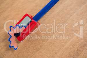 Blue color pencil being sharpened on wooden background