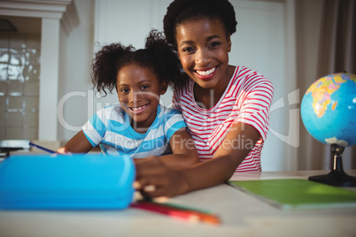 Portrait of mother assisting daughter with homework Portrait of mother assisting daughter with homework