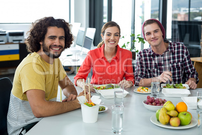 Smiling business executives having meal in office