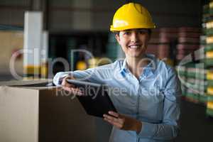 Female factory worker standing with digital tablet in factory