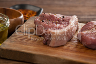 Sirloin chops on wooden board with ingredients