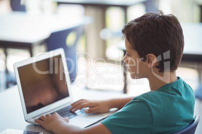 Schoolboy using laptop in classroom Schoolboy using laptop in classroom