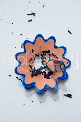 Blue color pencil shavings in a flower shape on a white background