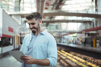 Smiling executive using digital tablet on platform