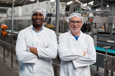 Portrait of two factory engineers standing with arms crossed