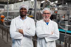 Portrait of two factory engineers standing with arms crossed
