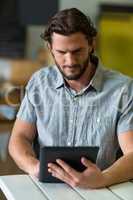 Male staff using digital tablet in grocery shop