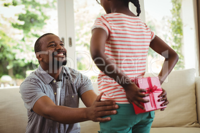 Daughter hiding gift behind her back for father