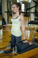 Woman performing stretching exercise on reformer